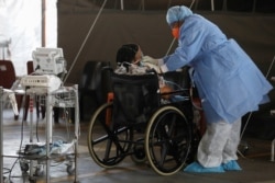 Healthcare workers tend to a patient at a temporary ward set up during the coronavirus disease (COVID-19) outbreak, at Steve Biko Academic Hospital in Pretoria, South Africa, January 19, 2021.