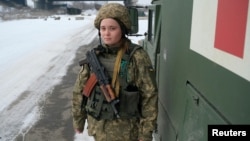 Bolničarka ukrajinskih oružanih snaga stoji pored vojnog sanitetskog vozila u blizini linije razgranjčenja sa pobunjenicima koje podžava Rusija, na obodu sela Piski, u regionu Donjetska, Ukrajina, 26. januara 2022.