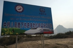 A sign in Luang Prabang shows in Lao and Chinese referring to the construction of the first rail line linking China to Laos, a key part of Beijing's 'Belt and Road' project across the Mekong, Feb. 8, 2020.