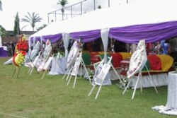 FILE - Flag-draped caskets of seven children who were killed by unidentified assailants in a classroom of a secondary school are pictured during their mass funeral in Kumba, Cameroon, Nov. 5, 2020.
