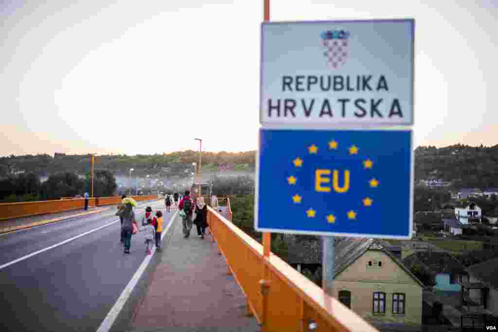 Migrants walking on bridge over Danube to Croatia. (A. Tanzeem/VOA)