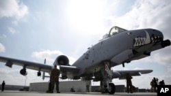 FILE - U.S. military personnel stand beside an A-10C fighter at Kandahar Airfield, Afghanistan, Jan. 23, 2018.