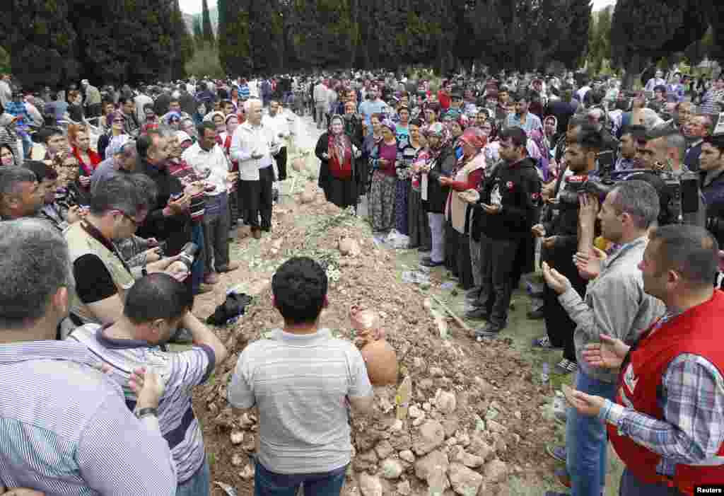 People mourn at the grave of a miner after a burial service, in Soma, May 15, 2014.