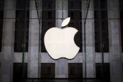 FILE - An Apple logo hangs above the entrance to the Apple Store on Fifth Avenue in the Manhattan borough of New York City,  July 21, 2015.