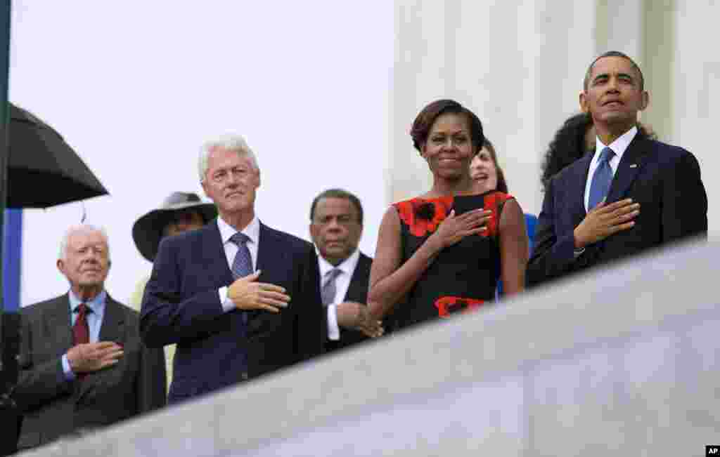From left, former President Jimmy Carter, former President Bill Clinton, former U.N. Ambassador Andrew Young, first lady Michelle Obama, and President Barack Obama stand for the national anthem during a ceremony commemorating the 50th anniversary of the March on Washington,&nbsp; Aug. 28,2013.