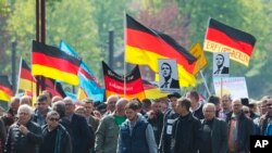 ប្រជាជន​កាន់ទង់ជាតិ​អំឡុង​ពេលបាតុកម្ម​ដែល​ផ្តួចផ្តើម​ដោយគណបក្ស​ជាតិនិយម​របស់អាល្លឺម៉ង់​ AfD (ជម្រើស​មួយទៀត​សម្រាប់​ប្រទេស​អាល្លឺម៉ង់) ក្នុងថ្ងៃ​ទិវាពលកម្ម ​ក្នុងទីក្រុង​ Erfurt ភាគ​កណ្តាល​ប្រទេស​អាល្លឺម៉ង់​ (រូបថត​ថ្ងៃទី១ ខែឧសភា​ ឆ្នាំ​២០១៧)។ 