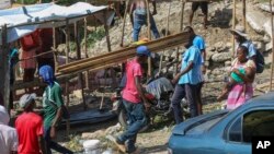 FILE - Residents of the Nazon neighborhood displaced by gang violence construct a tent encampment, in Port-au-Prince, Haiti, Nov. 15, 2024.