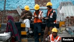 ពលករ​ញ៉ាំ​អាហារ​នៅ​ពេល​សម្រាក​ពី​ការងារ​នៅ​អគារ​ពាណិជ្ជកម្ម​ដែល​កំពុង​ត្រូវ​បាន​គេ​សាងសង់​នៅ​ក្នុង​ក្រុង Noida ប្រទេស​ឥណ្ឌា កាលពី​ថ្ងៃទី១៣ ខែធ្នូ ឆ្នាំ២០១៣។