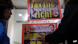 FILE - Placards featuring portraits of Chinese President Xi Jinping are displayed near an office of Panama law firm Mossack Fonseca in Hong Kong, April 12, 2016. The Panama Papers have shown relatives of members of the ruling elite owned offshore companies.