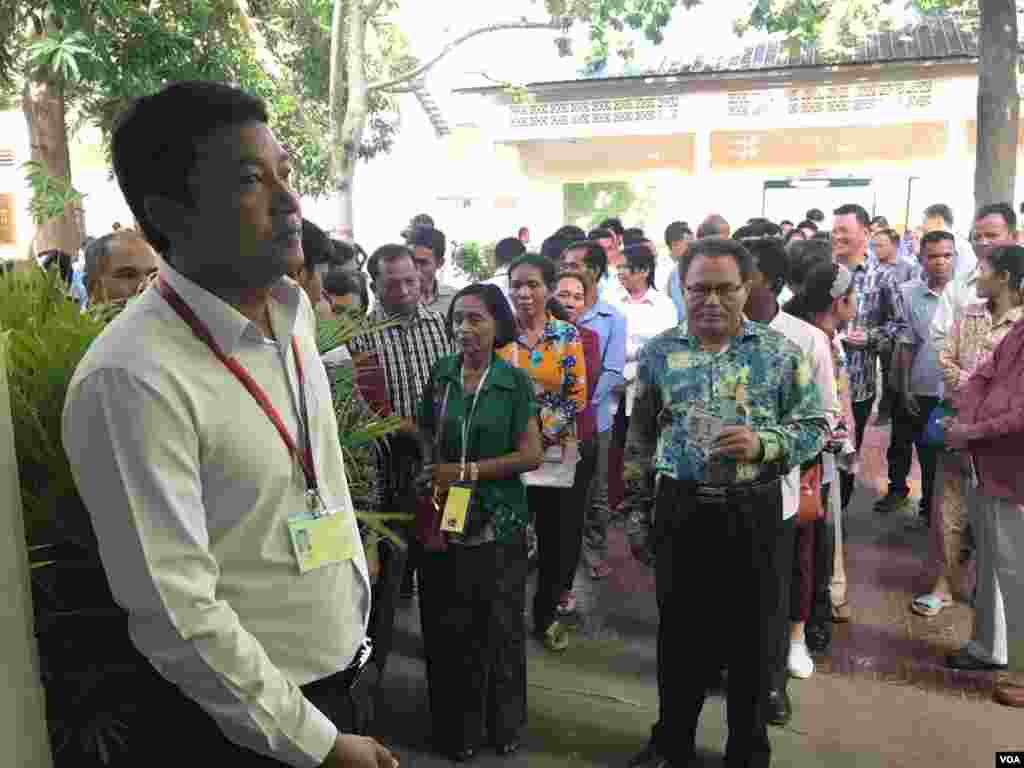 ពលរដ្ឋ​កម្ពុជា​តម្រង់​ជួរ​រង់​ចាំ​បោះឆ្នោត​នៅ​ការិយាល័យ​បោះឆ្នោត​មួយ​​កន្លែង​ក្នុងក្រុង​តាខ្មៅ​ ខេត្ត​កណ្តាល​ កាល​ពី​ព្រឹក​ថ្ងៃ​អាទិត្យ ទី​២៩ ខែ​កក្កដា ឆ្នាំ២០១៨។ (នៅ វណ្ណារិន/VOA)