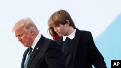 In this photo taken March 17, 2017, Barron Trump, with his father President Donald Trump and mother, first lady Melania Trump, disembark from Air Force One upon arrival at Palm Beach International Airport in West Palm Beach, Fla. 