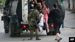 People are evacuated from the scene of an altercation involving police and an armed group in the northern Macedonian town of Kumanovo, May 9, 2015.