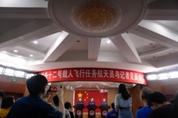 Chinese astronauts, from left, Tang Hongbo, Nie Haisheng, and Liu Boming listen to a journalist's question during a press conference at the Jiuquan Satellite Launch Center ahead of the Shenzhou-12 launch from Jiuquan in northwestern China.