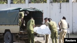 Tanzanian security forces remove the slain body of an attacker who was wielding an assault rifle, outside the French embassy in the Salenda area of Dar es Salaam, Tanzania, Aug. 25, 2021.