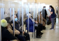 Seniors sit in a waiting room after receiving their vaccine against the coronavirus as Quebec begins vaccinations for seniors over 85 years old in Laval, Quebec, Canada, Feb. 25, 2021.
