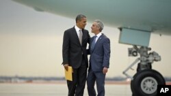 President Barack Obama is greeted by Chicago Mayor Rahm Emanuel upon his arrival on Air Force One at O'Hare International Airport in Chicago, Oct. 25, 2012. 