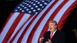 TOPSHOT - US President Donald Trump claps during a rally in support of Republican incumbent senators Kelly Loeffler and David Perdue ahead of Senate runoff in Dalton, Georgia on January 4, 2021. - President Donald Trump, still seeking ways to…