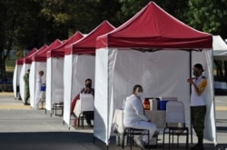 Medical personnel from different institutions and the Mexican Army wait to begin applying the Pfizer/BioNTech COVID-19 vaccine, at the Military Field Number 1A in Mexico City, Dec. 28, 2020.