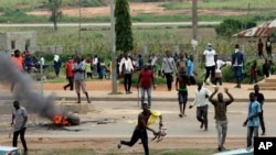 Protesters throw rocks at policemen during an attack on South African business, in Abuja, Nigeria, Sept. 4, 2019. 