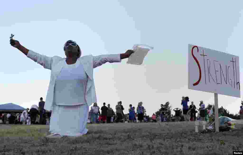 Marietta Perkins prays during a vigil for victims behind the theater where a gunman opened fire on moviegoers in Aurora, Colorado July 20, 2012.