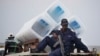 FILE - A policeman sits atop a minibus carrying empty ballot boxes to a central counting center in Democratic Republic of Congo's capital Kinshasa.