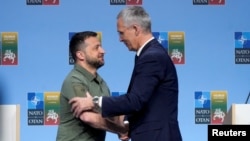 Presiden Ukraina Volodymyr Zelenskyy dan Sekretaris Jenderal NATO Jens Stoltenberg berjabat tangan saat konferensi pers di sela KTT para pemimpin NATO di Vilnius, Lithuania, 12 Juli 2023. (Foto: REUTERS/Ints Kalnins)