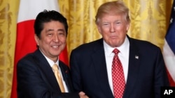 President Donald Trump, right, and Japanese Prime Minister Shinzo Abe shake hands following their joint news conference in the East Room of the White House in Washington, Feb. 10, 2017. 