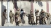FILE - Afghan security personnel rescue a man from the Shamshad TV compound after an attack in Kabul, Nov. 7, 2017.