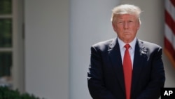 FILE - President Donald Trump stands next to the podium after speaking about the U.S. role in the Paris climate change accord in the Rose Garden of the White House in Washington, June 1, 2017. 