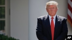 FILE - President Donald Trump stands next to the podium after speaking about the U.S. role in the Paris climate change accord in the Rose Garden of the White House in Washington, June 1, 2017. 