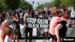 Protesters gather at the scene where George Floyd, an unarmed black man, was pinned down by a police officer kneeling on his neck before later dying in hospital in Minneapolis, Minnesota, May 26, 2020.