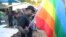 FILE - Chesterfield Samba, director of Gays and Lesbians of Zimbabwe, prepares to hoist the pride flag alongside the Zimbabwean flag during an event in Harare, May, 19, 2012. Zimbabwe's vice president on Feb. 15, 2024, threatened the group for offering university scholarships.