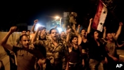 Sryian soldiers celebrate Bashar Assad's presidential re-election in Damascus, Syria, Wednesday, June 4, 2014.