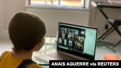 FILE - A school kid socializes with peers online following school closures due the spread of the coronavirus disease (COVID-19) outbreak, in London, Britain, March 20, 2020 in this picture obtained from social media on March 25, 2020. 