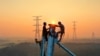 Employees work on a high voltage transmission tower in Yichun, in China&#39;s central Jiangxi province, Sept. 28, 2021.