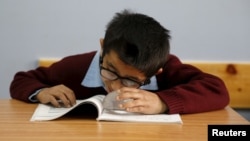 FILE - A visually impaired Palestinian student attends a lesson at a school, where the pupils are taught English through song and music, in the West Bank city of Hebron, March 2, 2016. Palestinian students at a school for the blind in the West Bank are learning English through song, a welcome departure from using Braille and memorizing grammar rules.