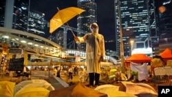 Seorang peserta aksi protes memegang payung kuning dalam sebuah pertunjukkan di jalan utama wilayah Admiralty, Hong Kong, 9 Oktober 2014 (Foto: dok). Ribuan warga diperkirakan akan turun ke jalan-jalan di Hong Kong, Jumat (30/6). 