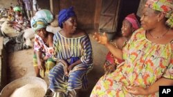 Women rice sellers chat in a busy market in Kindia, Guinea in this Aug. 21, 2002 photo. 