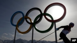 FILE – A skier passes by the Olympic rings at the 2014 Winter Olympics, in Krasnaya Polyana, Russia, Feb. 20, 2014. The International Association of Athletics Federations postponed a final decision over Russia's eligibility for the 2016 Olympics until May.