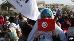 A supporter of the Islamic Ennahda party displays her national flag during a rally in Ben Arous, south of Tunis, October 21, 2011.