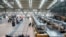 Passengers stand in front of counters at Hamburg Airport, Germany, March 9, 2025. (Georg Wendt/dpa via AP)