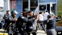 Policías antidisturbios desalojan a periodistas de la entrada principal de la Comandancia General de la Policía Nacional. La policía nicaraguense ha sido señalada de numerosos atropellos a los derechos humanos. 