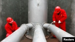 FILE - Laborers work at a PetroChina refinery in Suining, southwest China's Sichuan province.