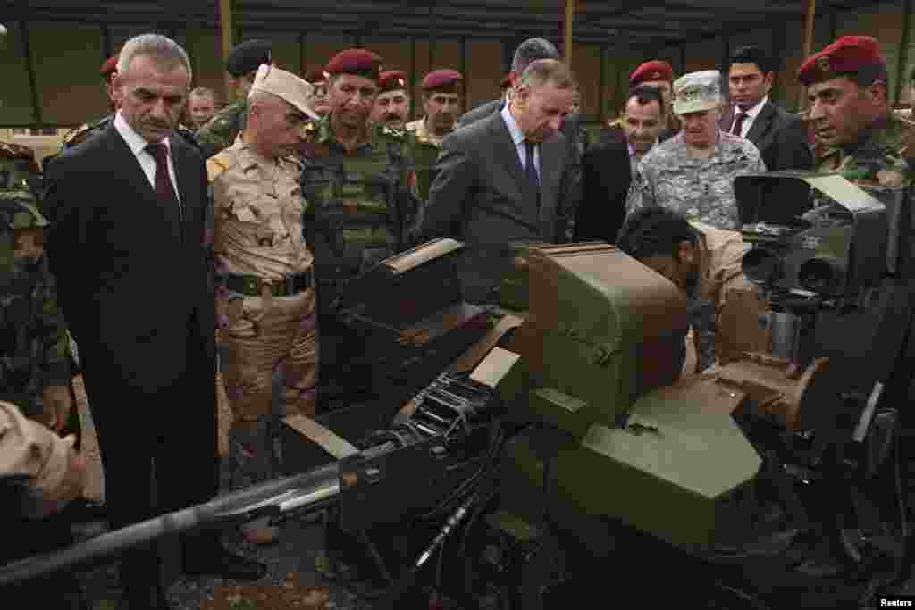 Iraqi Defense Minister Khaled al-Obeidi, center, watches a skill demonstration while visiting a training camp for Kurdish peshmerga troops in Irbil, Nov. 3, 2014. 