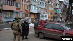 Ukrainian police officers try to persuade residents to evacuate from the frontline town of Pokrovsk