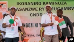 Burundi Army Gen. Evariste Ndayishimiye, left, is accompanied by current president Pierre Nkurunziza, right, after he was chosen as the party's presidential candidate at a national conference in Burundi, Jan. 26, 2020.