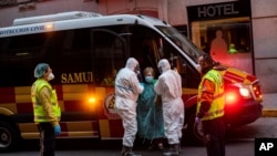 A patient, center, is transferred to a medicalized hotel during the COVID-19 outbreak in Madrid, Spain, March 24, 2020.