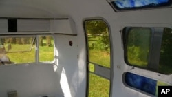 This is the interior of a much bigger Airstream, parked in a tranquil setting.