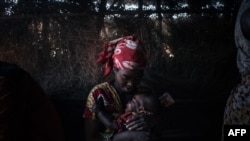 A displaced woman cares for her child, who suffers from acute diarrhea, in the makeshift health center of the internally displaced persons camp of Bijombo, South Kivu Province, eastern Democratic Republic of Congo, Oct. 10, 2020. 