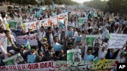 FILE - Students chant slogans while holding banners and posters showing Mumtaz Qadri, the alleged killer of Punjab governor Salman Taseer, during a rally to protest against any attempts to modify blasphemy laws, in Karachi, Pakistan, Jan. 20, 2011. Pakistani authorities on Feb. 29, 2016, hanged Qadri, a former police bodyguard. 